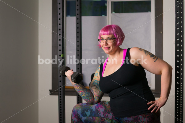 HAES Stock Photo: Female Weightlifter with Pink Hair Lifts Hand Weights in Gym - Body Liberation Photos