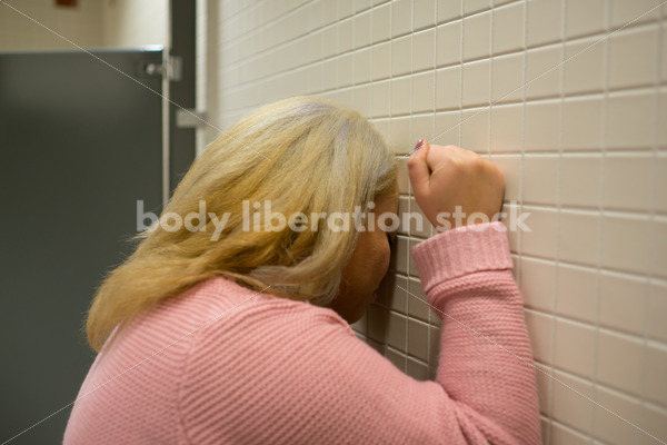 Mental Health and Illness Stock Image: Depressed Plus Size Woman in Office Building Bathroom - Body Liberation Photos