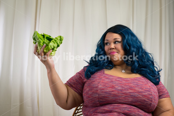 Royalty Free Stock Photo for Intuitive Eating: Black Woman Looks at Head of Lettuce - Body Liberation Photos