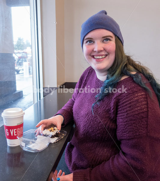 Young caucasian women enjoys coffee and a brownie