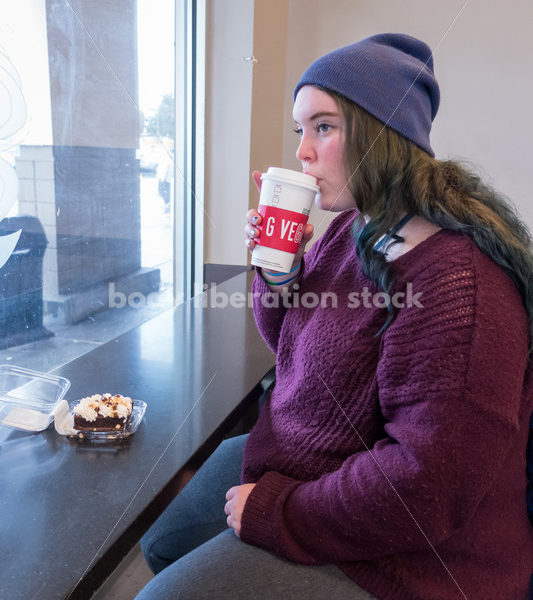 Young caucasian women enjoys coffee and a brownie