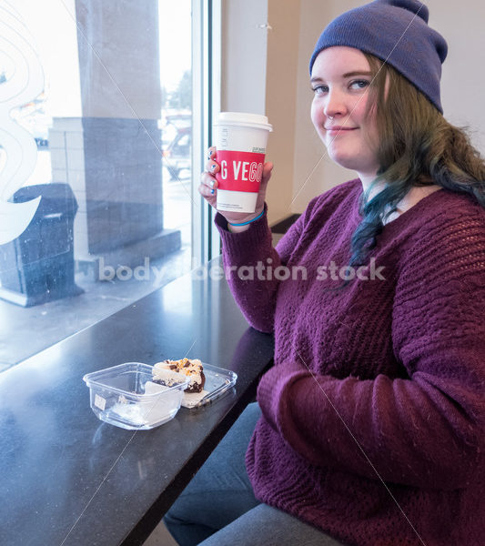 Young caucasian women enjoys coffee and a brownie