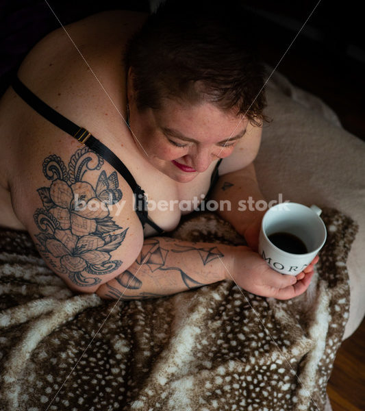 Body-Positive Stock Photo: Plus Size Woman Relaxing on Soft Blankets Holding a Cup