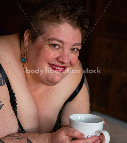 Body-Positive Stock Photo: Plus Size Woman Relaxing on Soft Blankets Holding a Cup